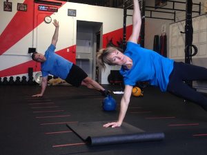 Man and woman in blue shirts doing a circuit training workout at 3 Strong Gym in San Ramon, CA