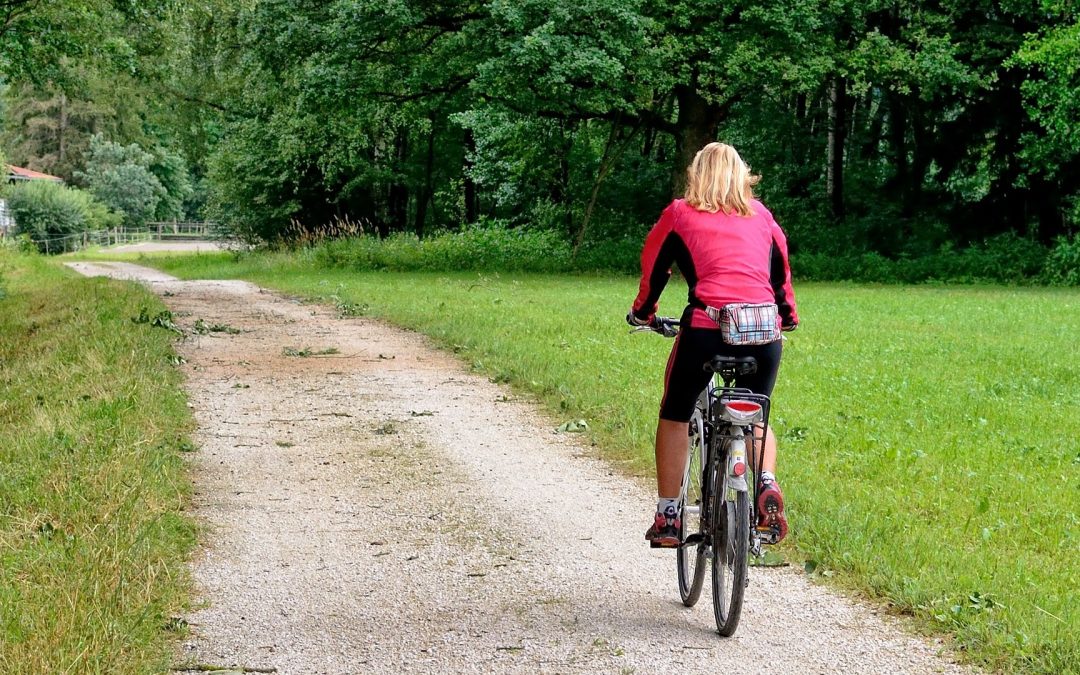 Woman cycling outdoors to stay fit and healthy during the summer
