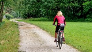 Woman cycling outdoors to stay fit and healthy during the summer